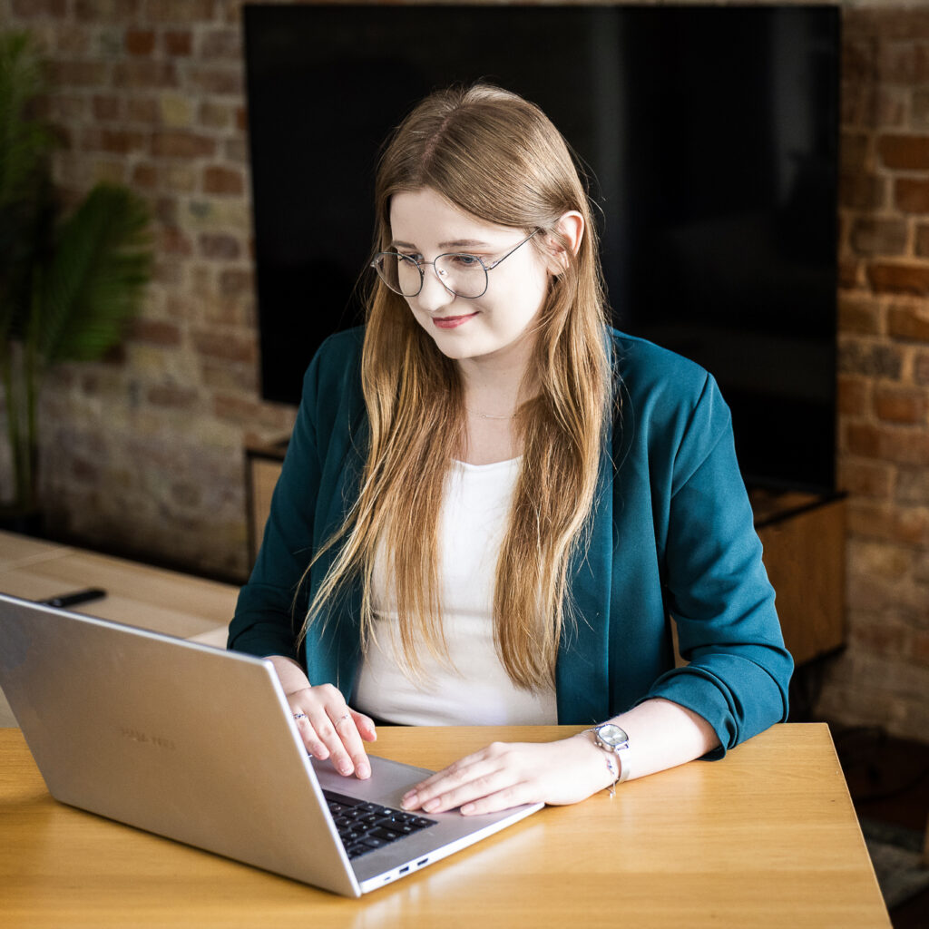 Członkini Towarzystwa GEST pracująca przy laptopie w biurze
