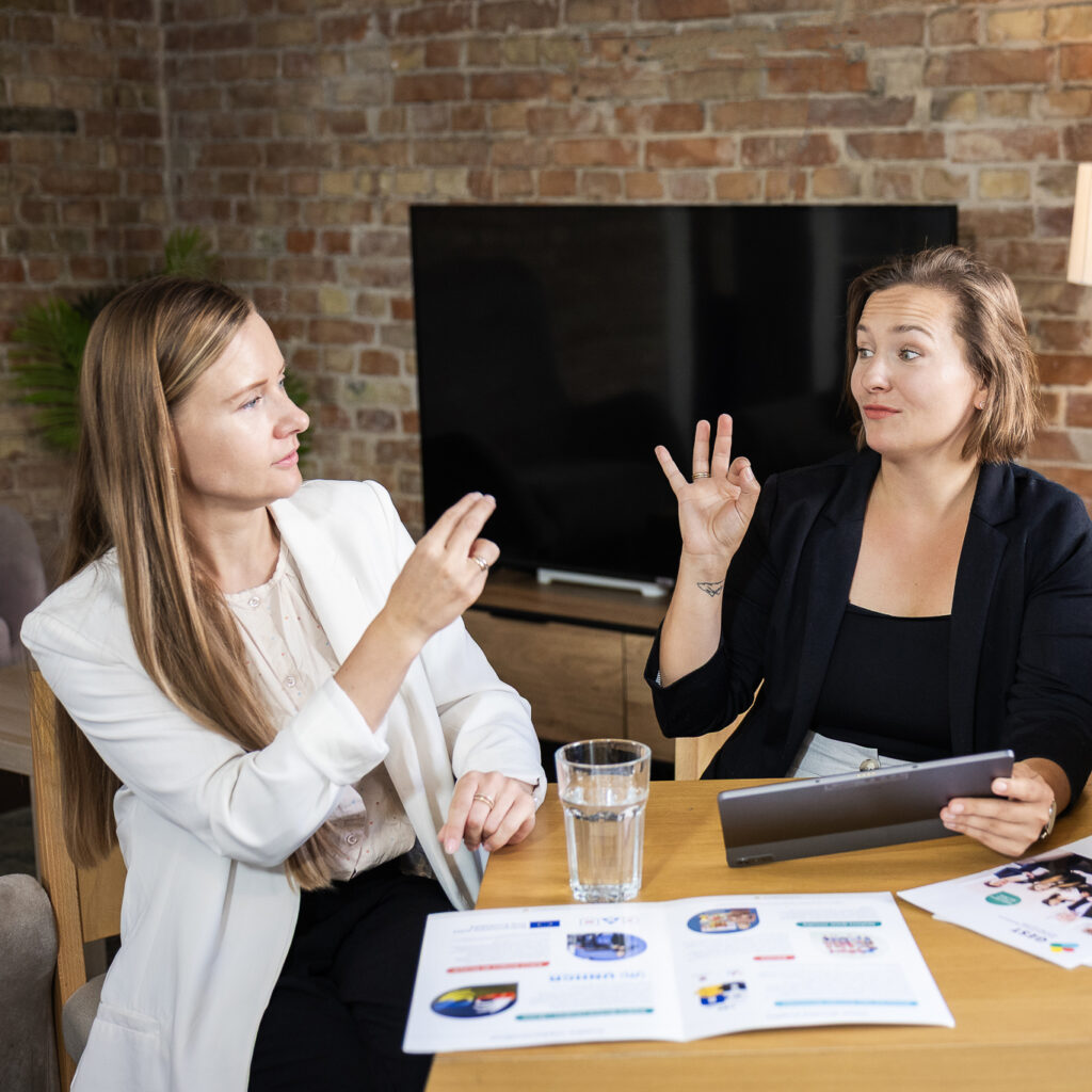 Członkinie Towarzystwa GEST rozmawiają w polskim języku migowym podczas spotkania